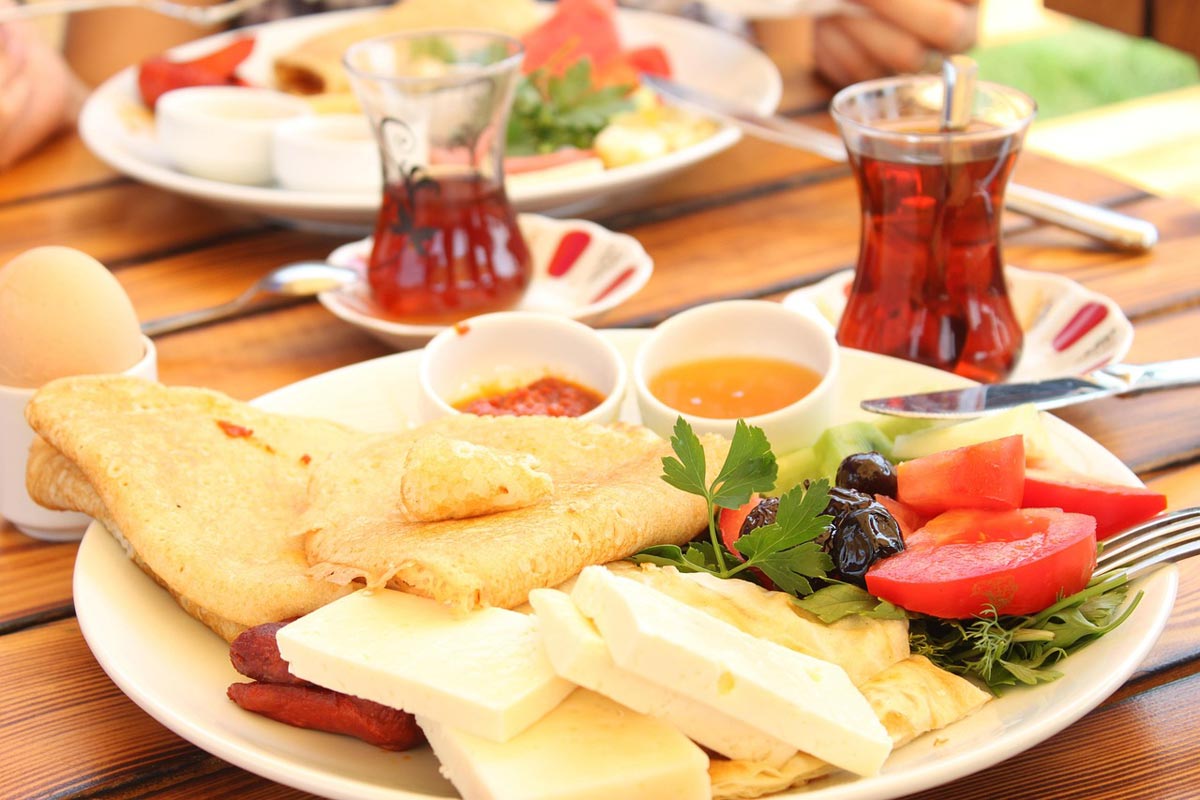 Gaststätte Schrammsteinbaude – Reichhaltiges Frühstücksbuffet Nahaufnahme eines Frühstückstisches mit Tee, Omelett, Frühstücksei, Käse, Gemüse und weiteren Beilagen